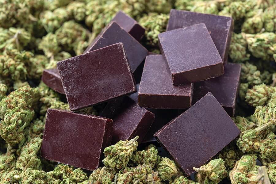 A pile of chocolate on top of a pile of marijuana leaves.