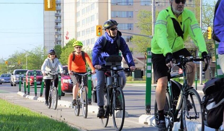 A group of people riding bicycles on a sidewalk.
