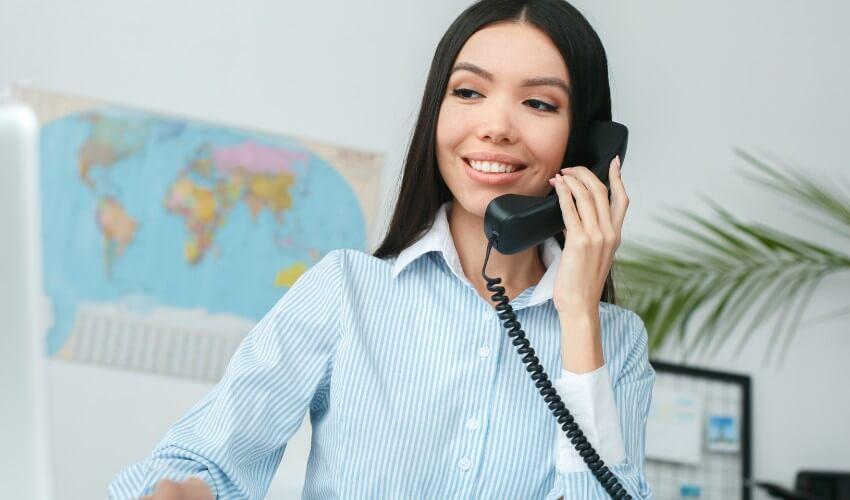 A woman is talking on the phone in an office.