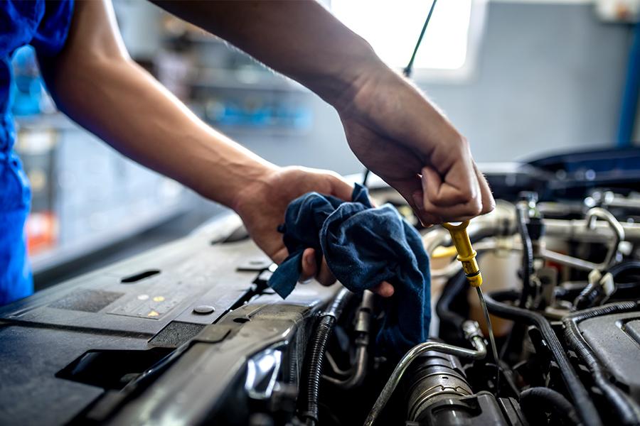 A mechanic is working on the engine of a car.