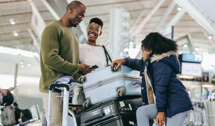 A man and woman standing next to luggage.