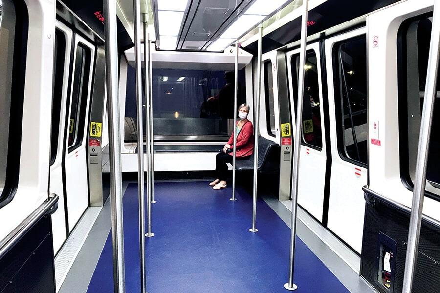 A woman is sitting on a subway train.