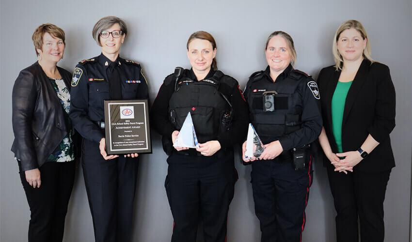 Four police officers standing next to each other holding an award.