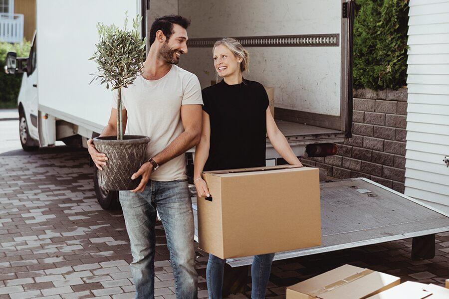 A man and woman standing in front of a moving truck.