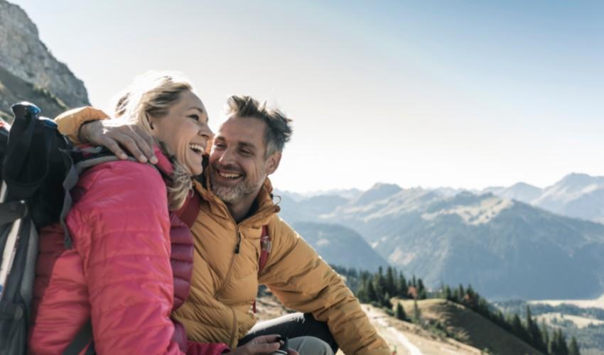 A couple hiking in the mountains with backpacks.