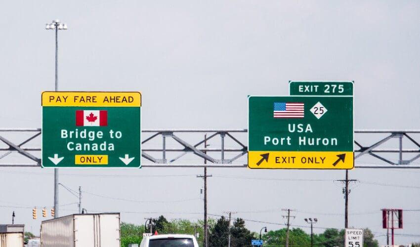 A highway with signs for canada and usa.