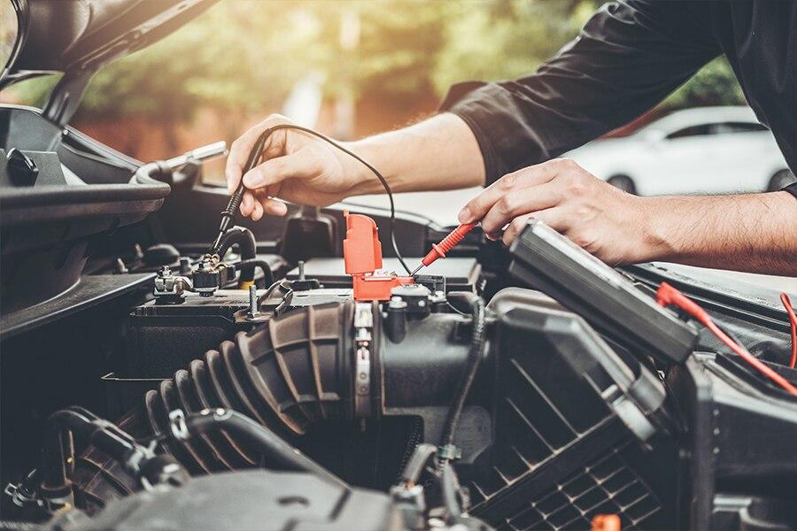 A man is working on the engine of a car.