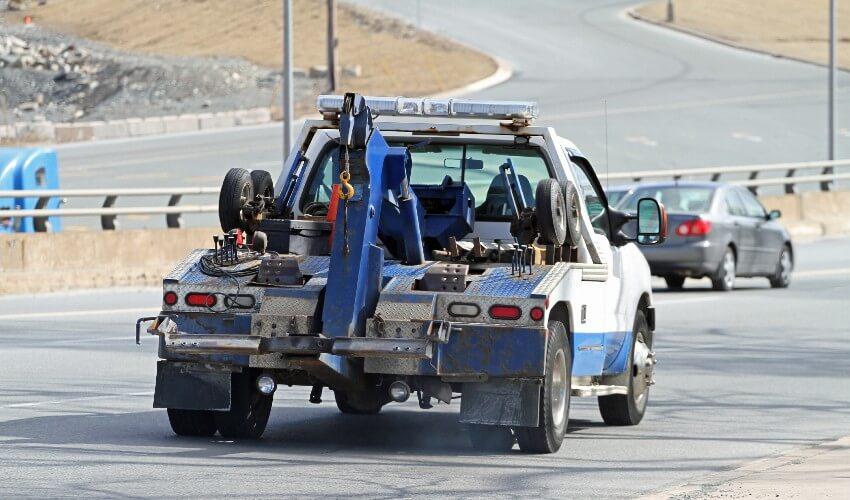 A tow truck is driving down the road.