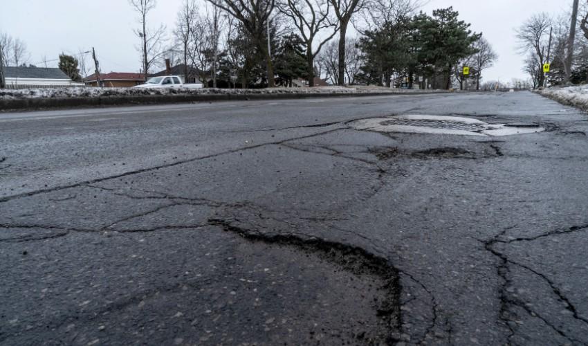 A road with potholes in the middle of the road.