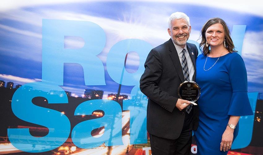 A man and woman standing in front of a sign that says road salt.