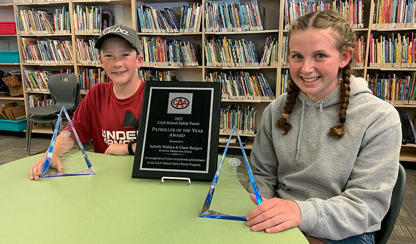 Two people sitting at a table with plaques in front of them.