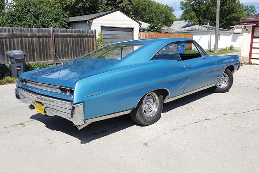 A blue car parked in a driveway.