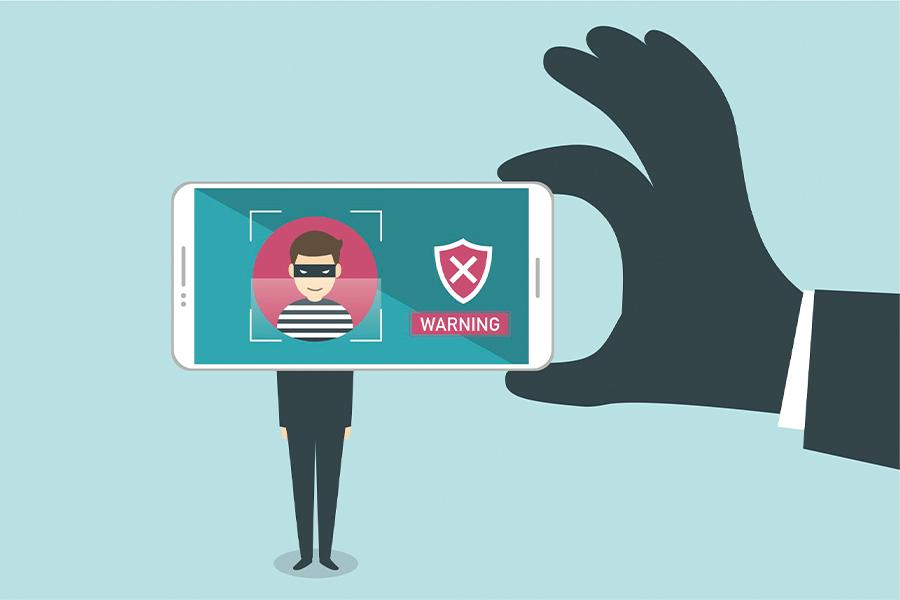 A man holding up a smartphone with a man in a mask.