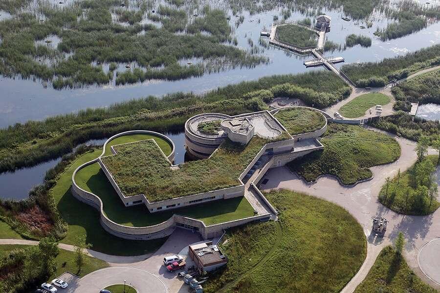 An aerial view of a fort with star-shaped bastions surrounded by water and greenery.
