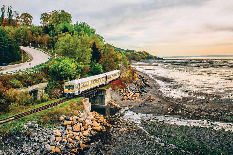 A train traveling along the coast near a body of water.
