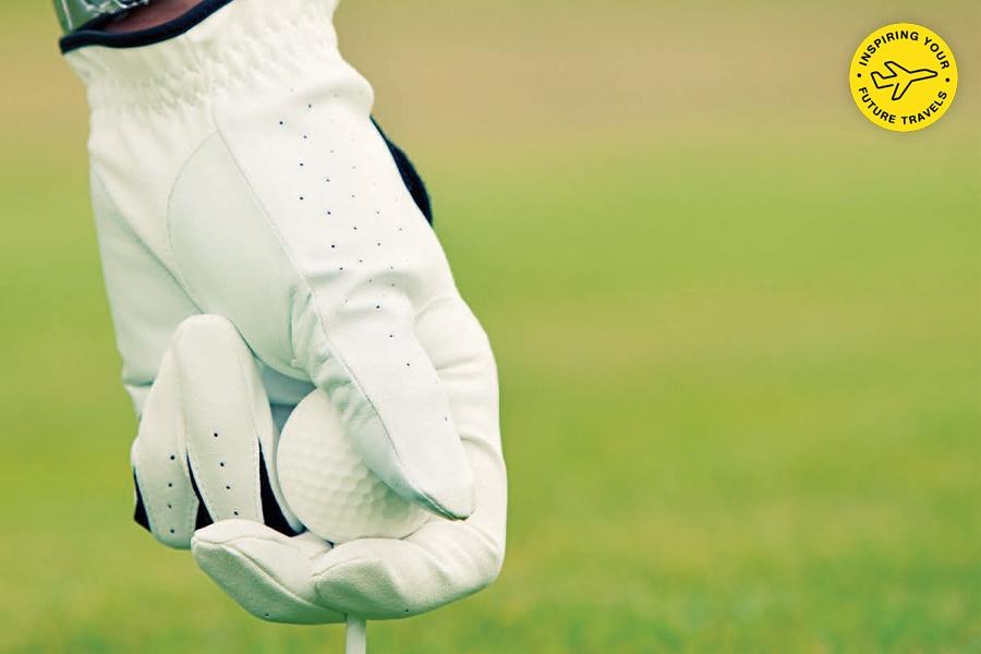 Golfer wearing a white glove gripping a golf club.
