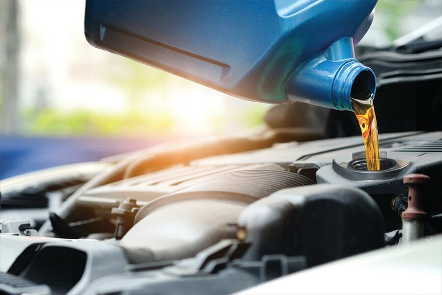 A pouring oil into a car engine.