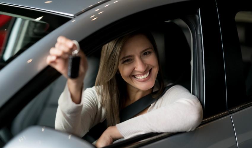 A woman holding a car key in her hand.
