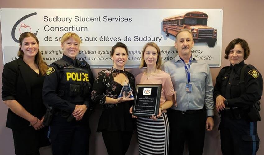 A group of people standing in front of a sign that says south sudbury student services consortium.