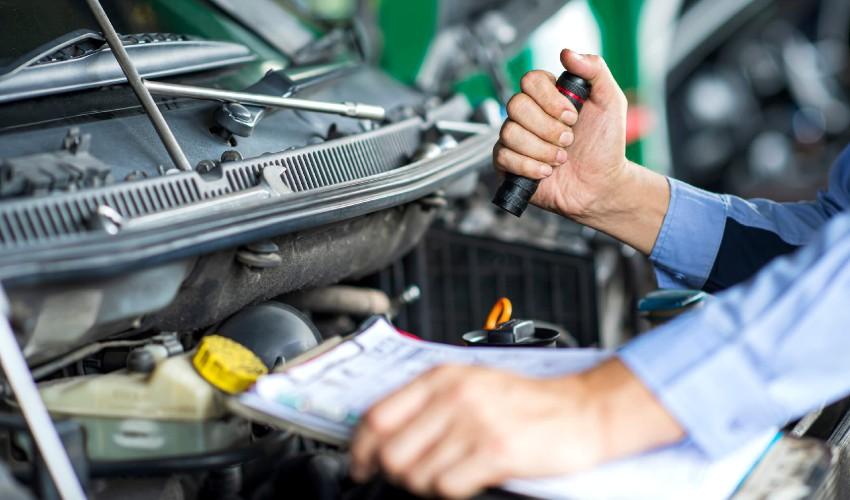 A mechanic checking the engine of a car.