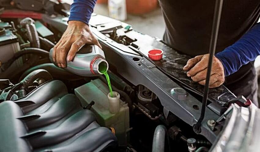 A man is working on the engine of a car.